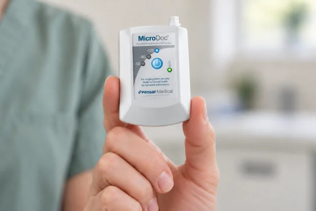Illustrative photograph: MicroDoc portable unit held in a hand to show its scale